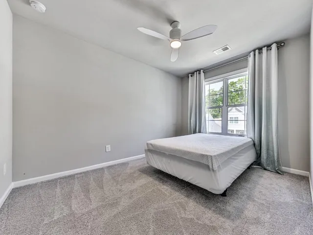 a spacious bedroom with a bed and a window