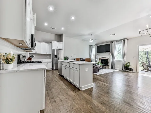 a kitchen with stove a sink and a refrigerator