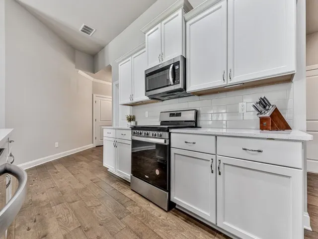 a kitchen with stainless steel appliances granite countertop white cabinets and a granite counter tops