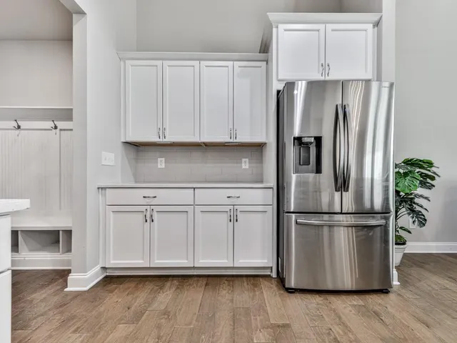 a kitchen with stainless steel appliances white cabinets and a wooden floor