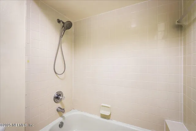 a bathroom with a bath tub with a shower