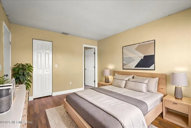 a bedroom with a bed and a painting on the wall