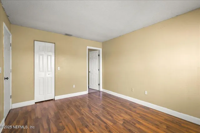 a view of an empty room with wooden floor