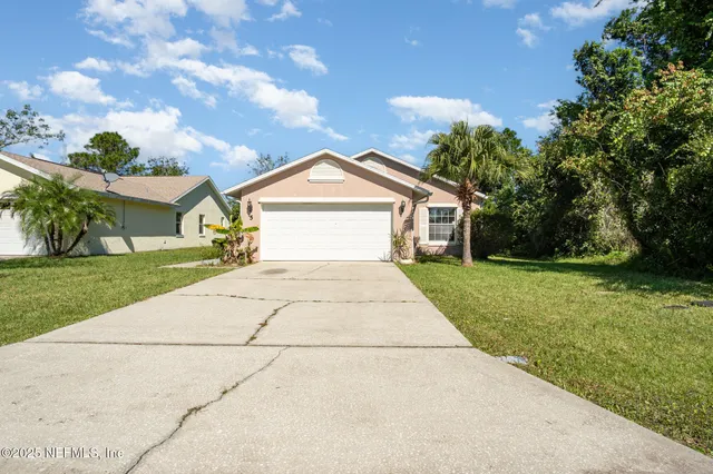 a front view of a house with a yard and trees