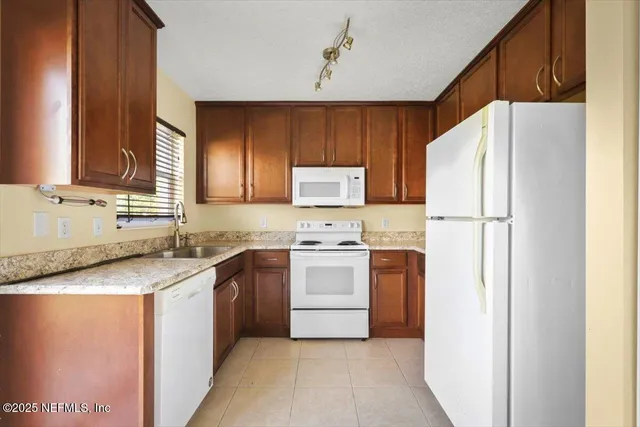 a kitchen with stainless steel appliances granite countertop a refrigerator a stove a sink and a microwave