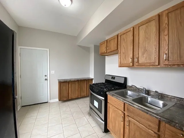 a kitchen with stainless steel appliances granite countertop a stove a sink and a white cabinets