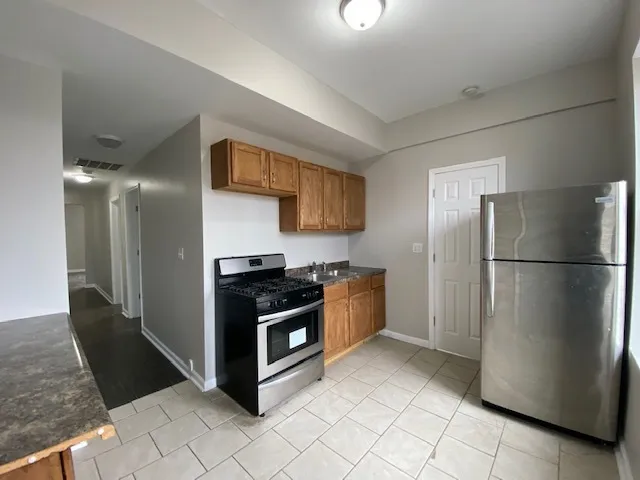 a kitchen with stainless steel appliances granite countertop a refrigerator and a stove
