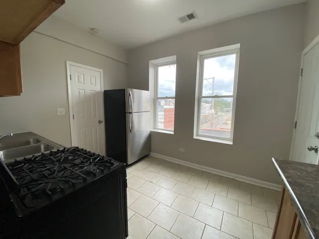 a kitchen with a stove a refrigerator and a window