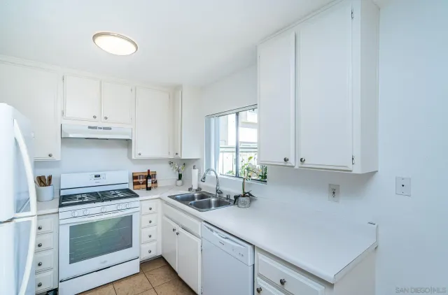 a kitchen with stainless steel appliances white cabinets and a sink