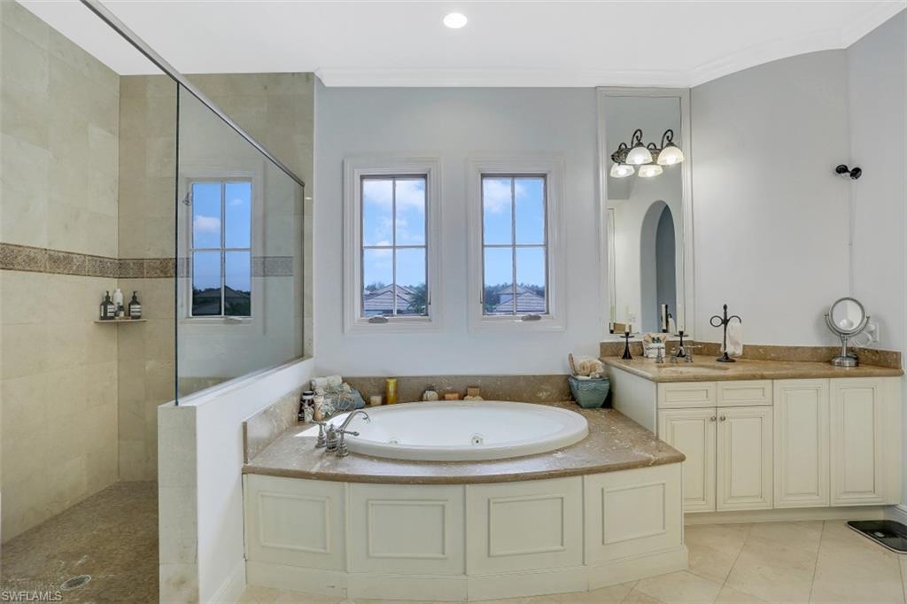 16649 Toscana Circle, Unit 806 Naples, FL 34110 - Photo 21 of 35 a bathroom with a granite countertop sink a mirror and shower