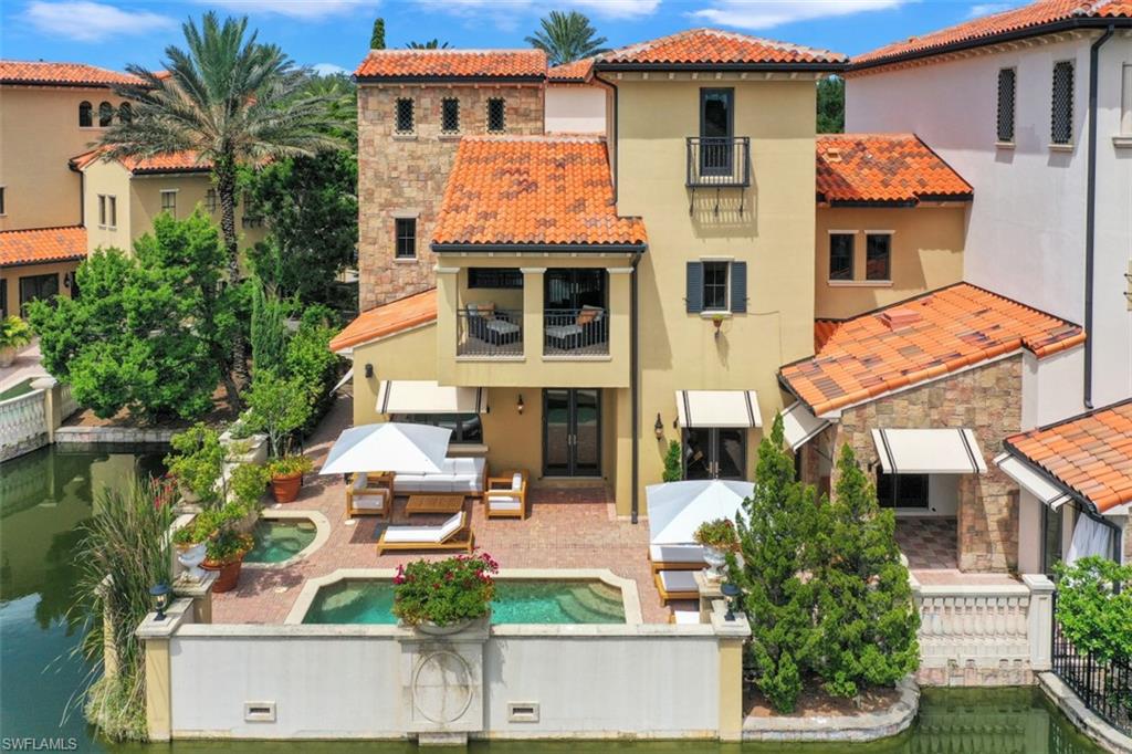 16649 Toscana Circle, Unit 806 Naples, FL 34110 - Photo 3 of 35 a view of a white house with large windows and a table and chairs
