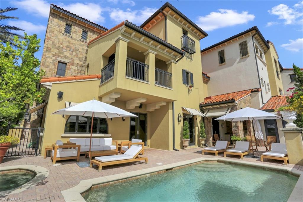 16649 Toscana Circle, Unit 806 Naples, FL 34110 - Photo 4 of 35 a view of a patio with a table and chairs under an umbrella