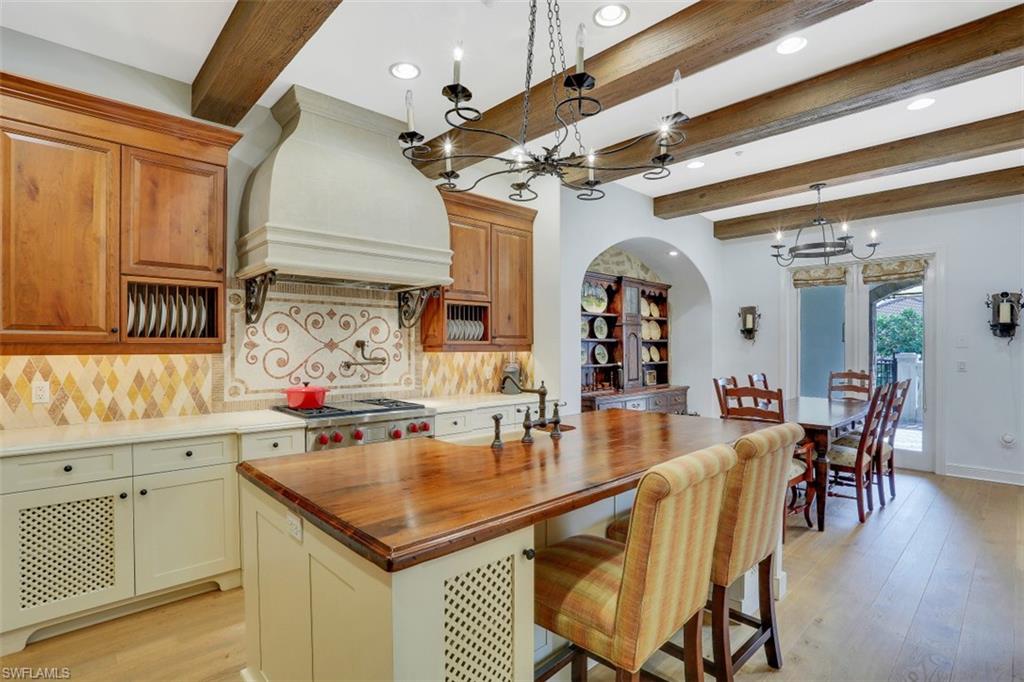 16649 Toscana Circle, Unit 806 Naples, FL 34110 - Photo 9 of 35 a kitchen with a table chairs and wooden floor