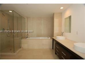 495 Brickell Avenue, Unit 3603 Miami, FL 33131 - Photo 21 of 48 a bathroom with a sink a mirror and a bathtub