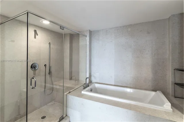 a bathroom with a tub a toilet and a shower