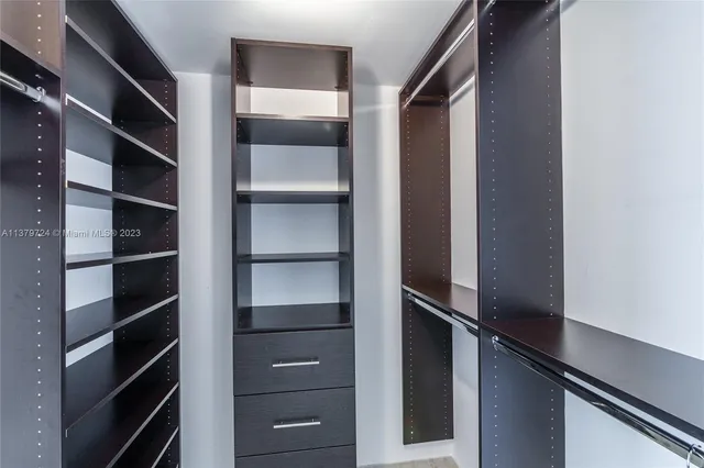 a view of walk in closet with empty racks