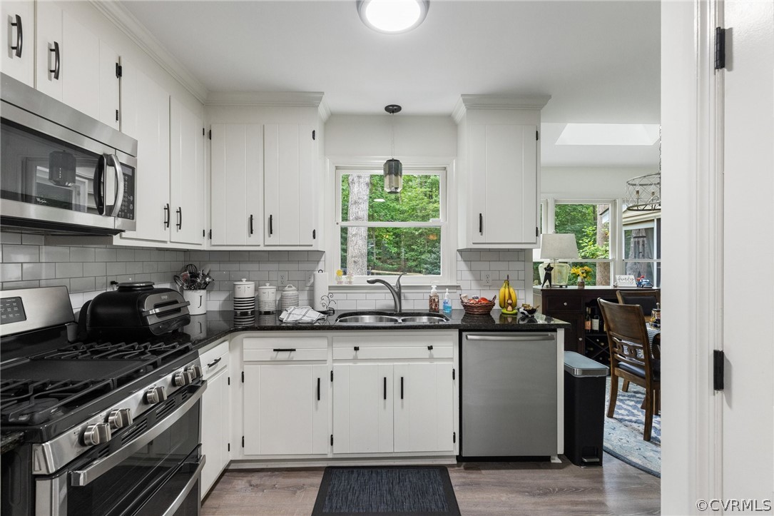 5603 Standing Oak Road Midlothian, VA 23112 - Photo 17 of 39 a kitchen with stainless steel appliances granite countertop a stove a sink dishwasher and cabinets with wooden floor