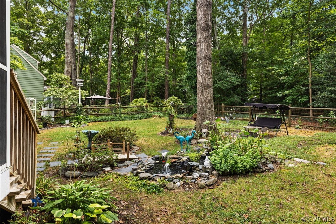 5603 Standing Oak Road Midlothian, VA 23112 - Photo 32 of 39 a backyard of a house with lots of green space and fountain in front of the house
