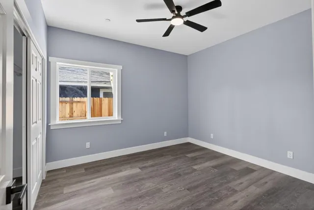 a view of a big room with wooden floor and windows