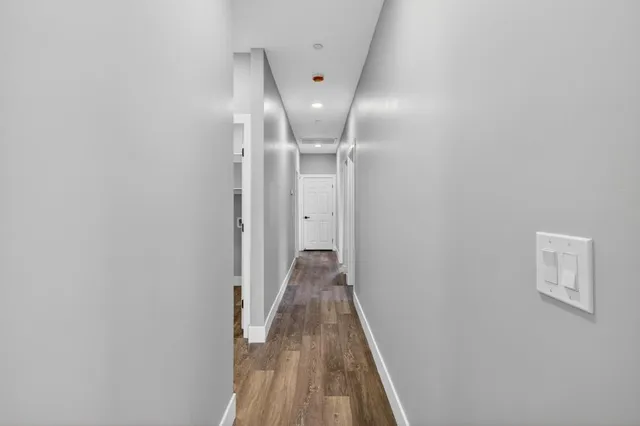 a view of a hallway with wooden floor