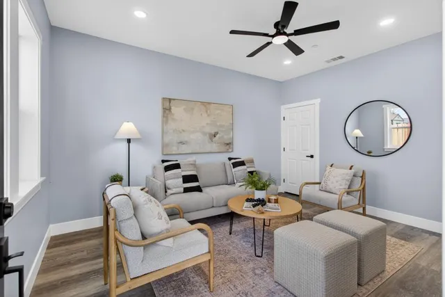 a living room with furniture a mirror and a large window