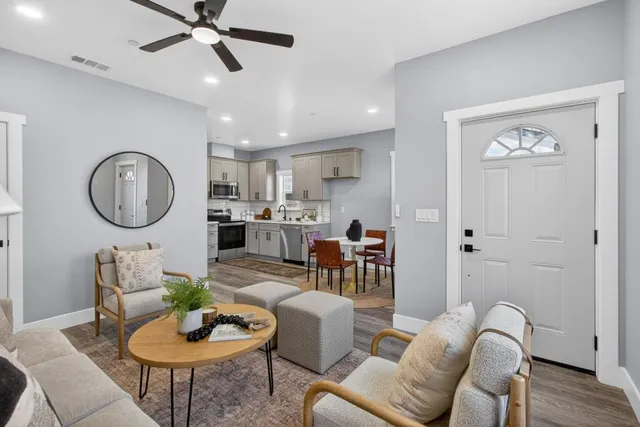 a living room with furniture kitchen view and a window