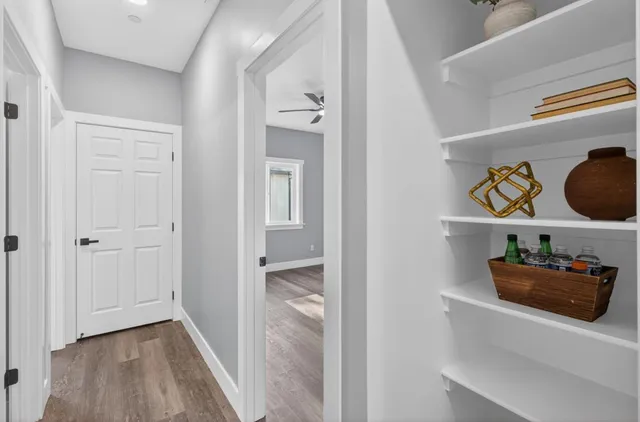 a hallway with front door wooden floor and windows