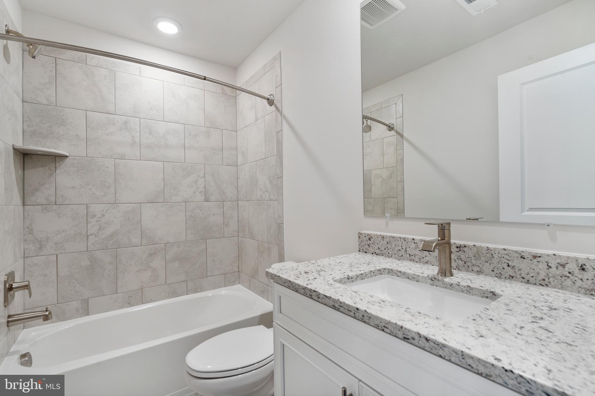 1425 Clingmans Dome Drive Frederick, MD 21702 - Photo 19 of 46 a bathroom with a granite countertop sink a toilet and bathtub