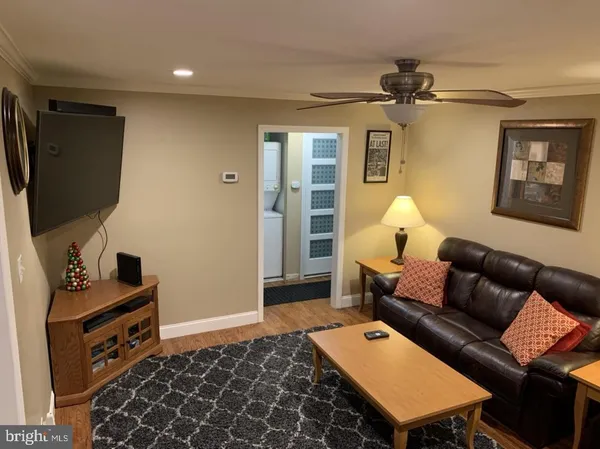 a living room with furniture a air conditioner and a flat screen tv