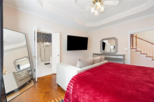 a bedroom with a bed a flat screen tv and a chandelier