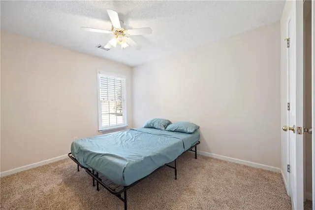 a bedroom with a bed and a ceiling fan