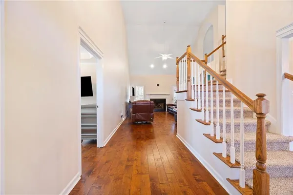 a view of a hallway with wooden floor and staircase