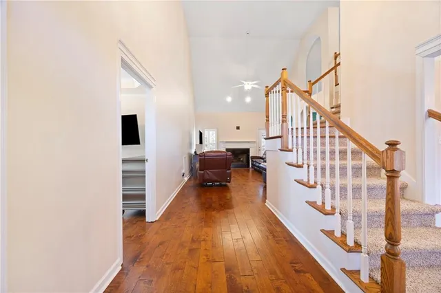 a view of a hallway with wooden floor and staircase