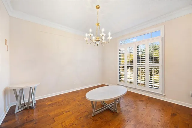 a view of a room with wooden floor table and chairs