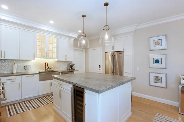 a kitchen with stainless steel appliances granite countertop a sink a stove a refrigerator and island