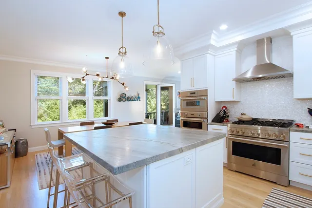 a kitchen with a stove a microwave and wooden floor