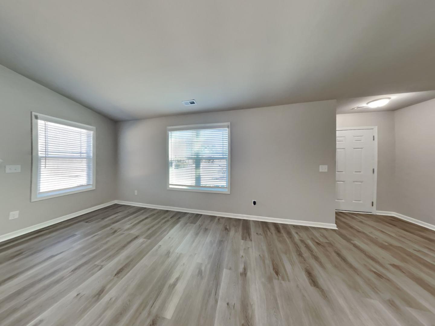 169 Willow Ridge Circle Willow Spring, NC 27592 - Photo 3 of 17 an empty room with wooden floor and windows