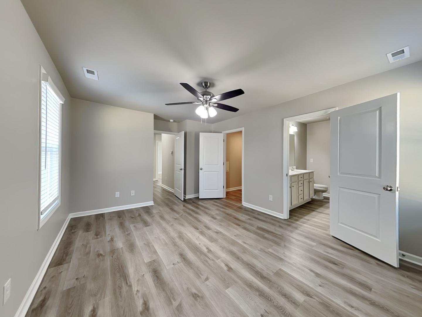 169 Willow Ridge Circle Willow Spring, NC 27592 - Photo 7 of 17 an empty room with wooden floor ceiling fan and windows