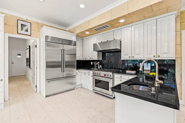 a kitchen with stainless steel appliances granite countertop a refrigerator a stove and a sink