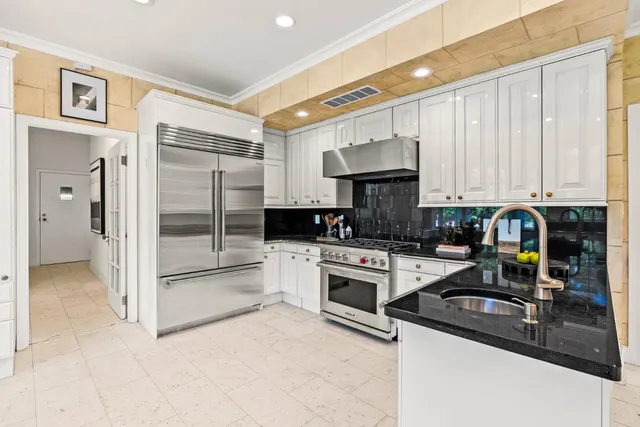 a kitchen with stainless steel appliances granite countertop a refrigerator a stove and a sink