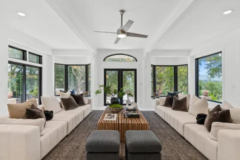 a living room with furniture and large windows