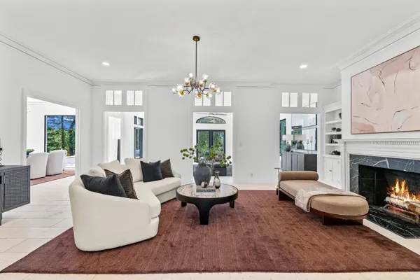 a living room with furniture a chandelier a fireplace and a chandelier