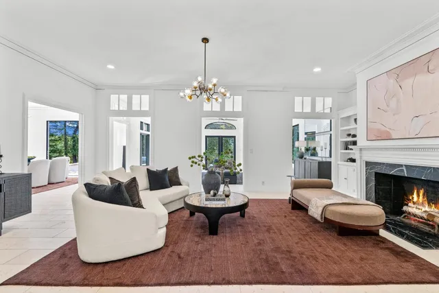 a living room with furniture a chandelier a fireplace and a chandelier