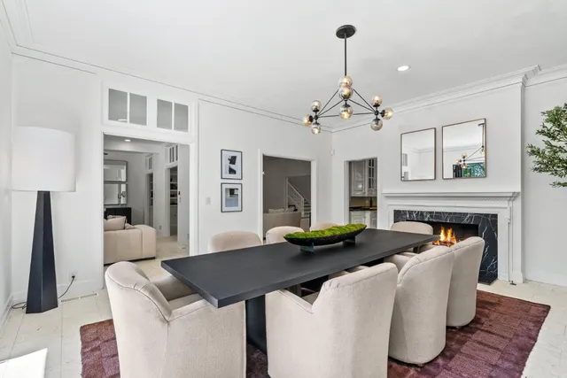 a living room with furniture a fireplace and a chandelier