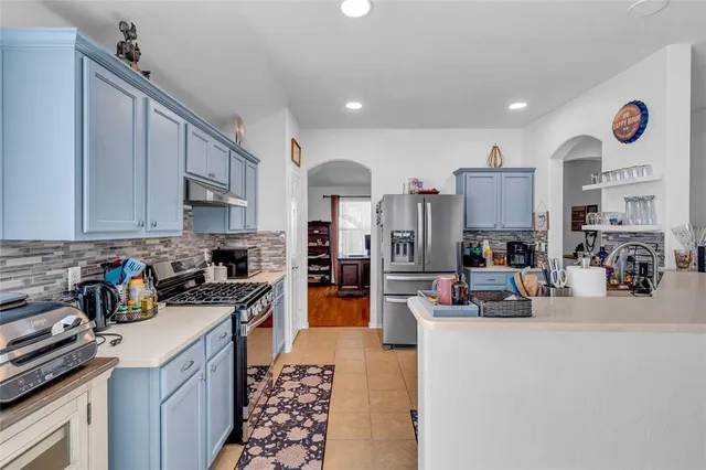 a kitchen with refrigerator and cabinets