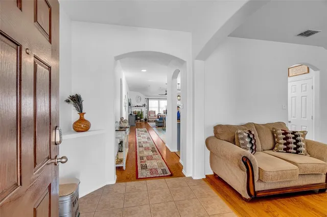 a living room with furniture a bookshelf and a window
