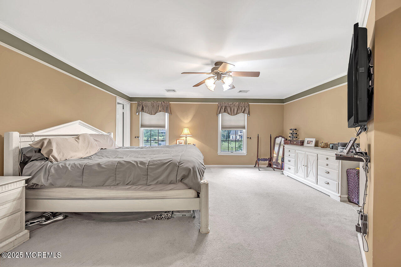 4 Cranberry Court Cream Ridge, NJ 08514 - Photo 24 of 51 a spacious bedroom with a large bed and a chandelier