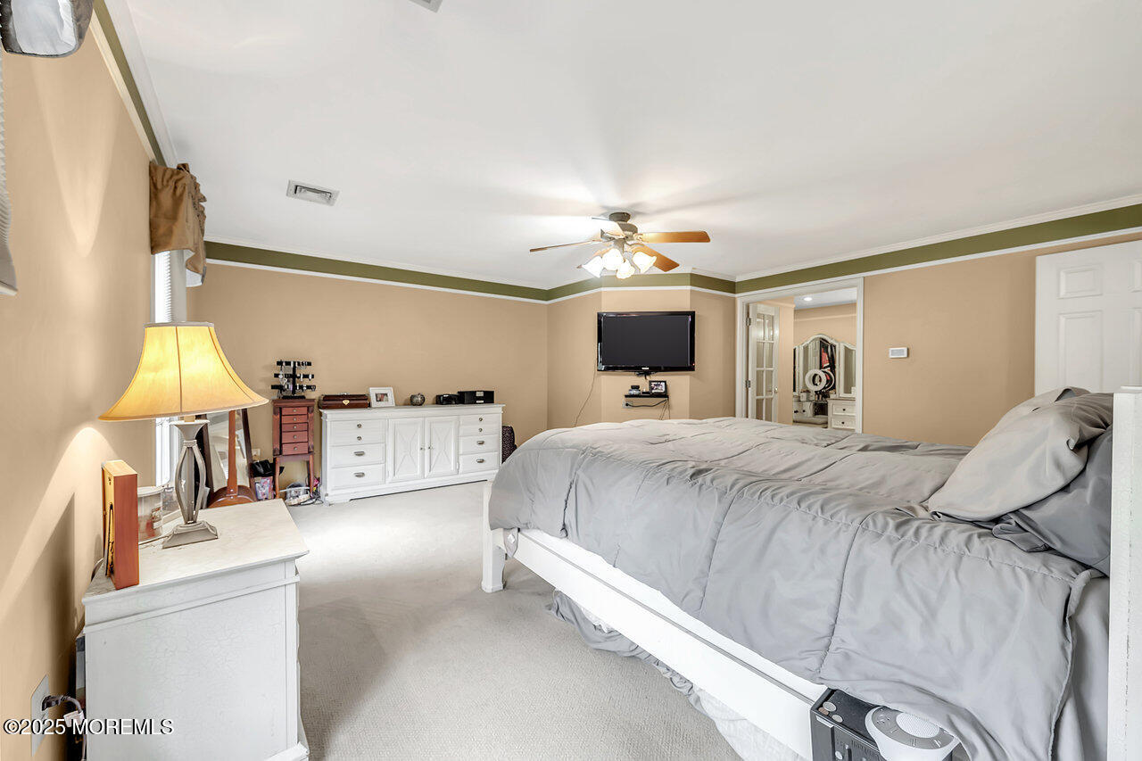 4 Cranberry Court Cream Ridge, NJ 08514 - Photo 25 of 51 a bed room with a bed and a chandelier