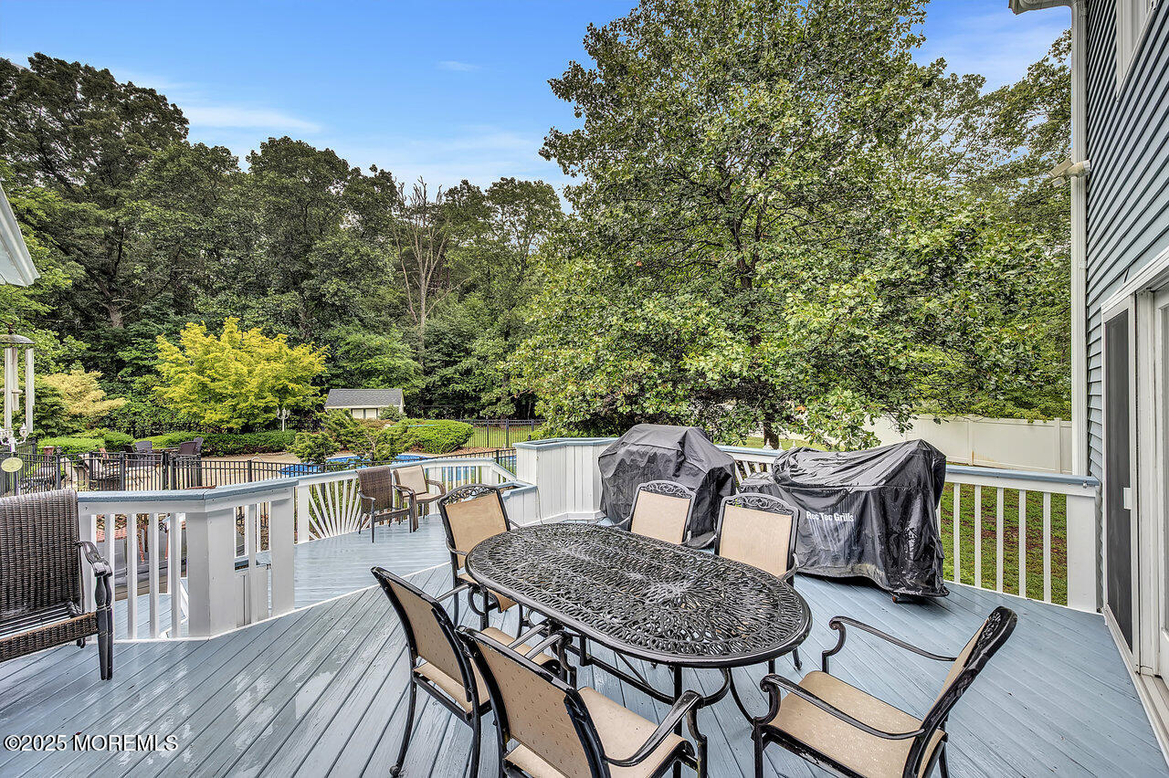 4 Cranberry Court Cream Ridge, NJ 08514 - Photo 41 of 51 a patio with wooden floor a yard a fountain and a glass top table and chairs with mountain view
