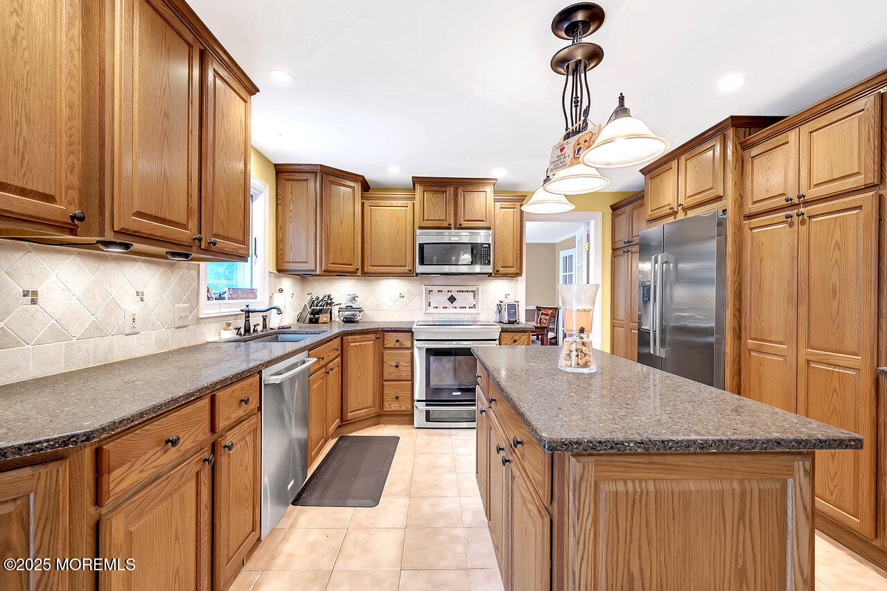 4 Cranberry Court Cream Ridge, NJ 08514 - Photo 10 of 51 a kitchen with stainless steel appliances granite countertop a sink a stove and a wooden cabinets